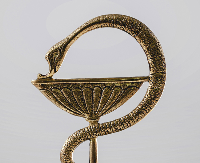 Escultura dorada con el emblema de la farmacia